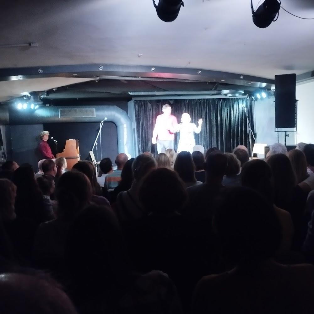 A man and woman perform on stage in front of a large audience.